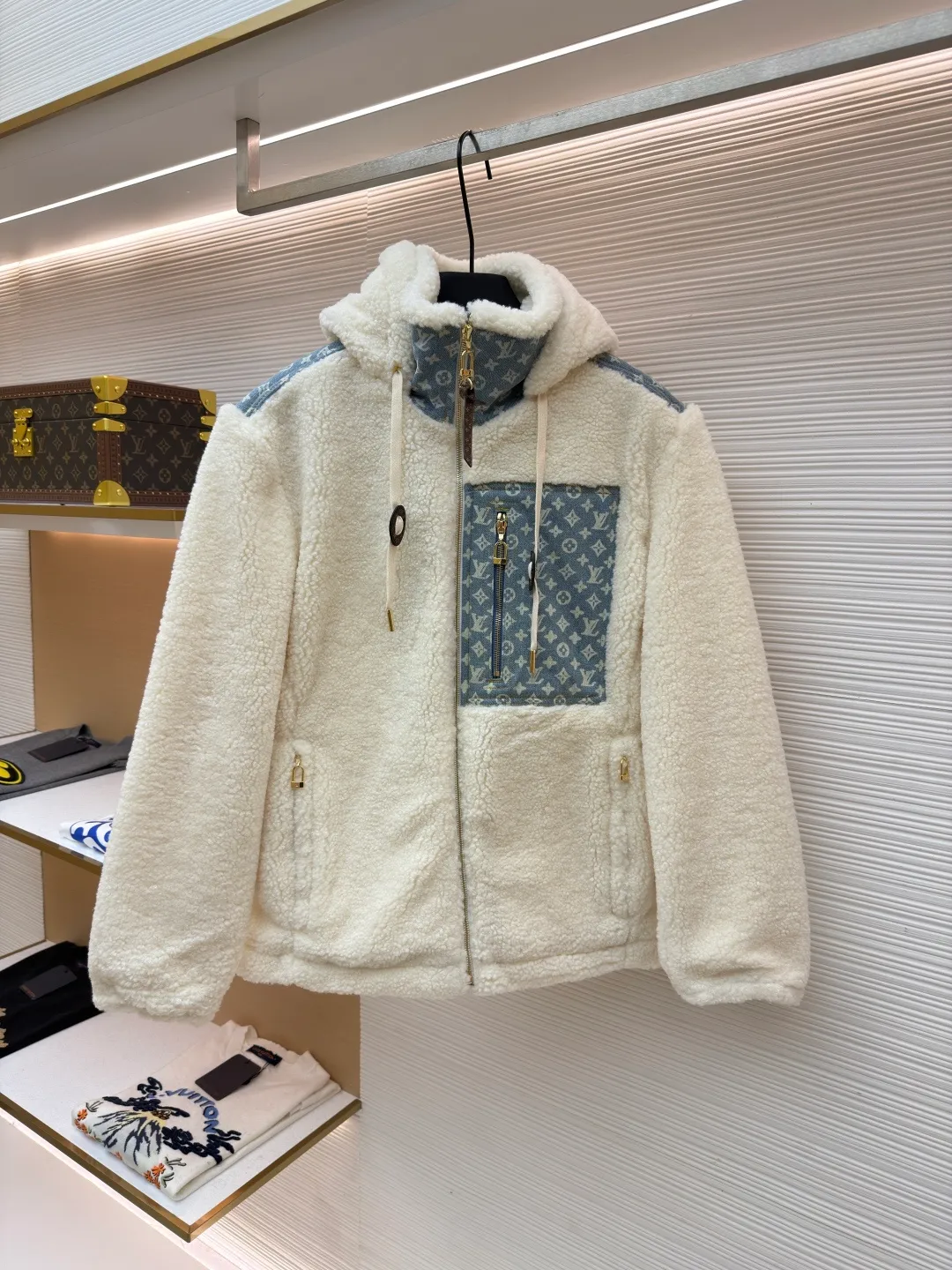 LOUIS VUITTON Letter jacquard splicing lamb wool ski hooded jacket ●Original version: purchased and developed by 26909 ●Item number: 1682241-C35 ●Fabric: lamb wool fabric ●Technology: jacquard production ●Color: off-white ●Version: fitted version ●Weight: about 1245 grams ●Size: 34-36-38-40-42-44 ●Description: The main body of this lamb wool spliced denim jacket is made of imported imitation lamb wool fabric, which has been processed by carding and shaping processes. The wool feels fluffy and soft and is not easy to shed and pill. The fabric has a uniform weight and has both warmth retention and breathability. The neckline, placket and chest pockets are spliced ​​with classic presbyopic denim. The denim is enzymatically washed to create a natural aged texture. The presbyopic pattern is embossed, making the texture three-dimensional and not easy to fall off. The body adopts a loose hooded fit, with a built-in shaping lining on the brim and an adjustable drawstring design; a custom metal zipper is used at the placket, and the chain teeth are gold-plated for smooth pulling and anti-oxidation. The edges of the pockets are reinforced with double stitching, and the splicing of lambswool and denim is made by hand caulking. The stitching is fine and smooth. Every detail is strictly controlled, showing the craftsmanship and quality of high-end clothing. The overall wiring is straight and delicate, the fabric is comfortable and soft, and the color is consistent without color difference. It can be matched with the same style to create a fashionable look and control various occasions. Customized accessories, complete with three standards, same style for men and women!